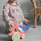A child placing a small pink Bajo rabbit on top of a big pink Bajo rabbit.  These heirloom quality toys by Bajo are part of a wide range of wooden toys available here at Babipur.