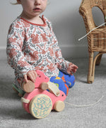 A child placing a small pink Bajo rabbit on top of a big pink Bajo rabbit.  These heirloom quality toys by Bajo are part of a wide range of wooden toys available here at Babipur.