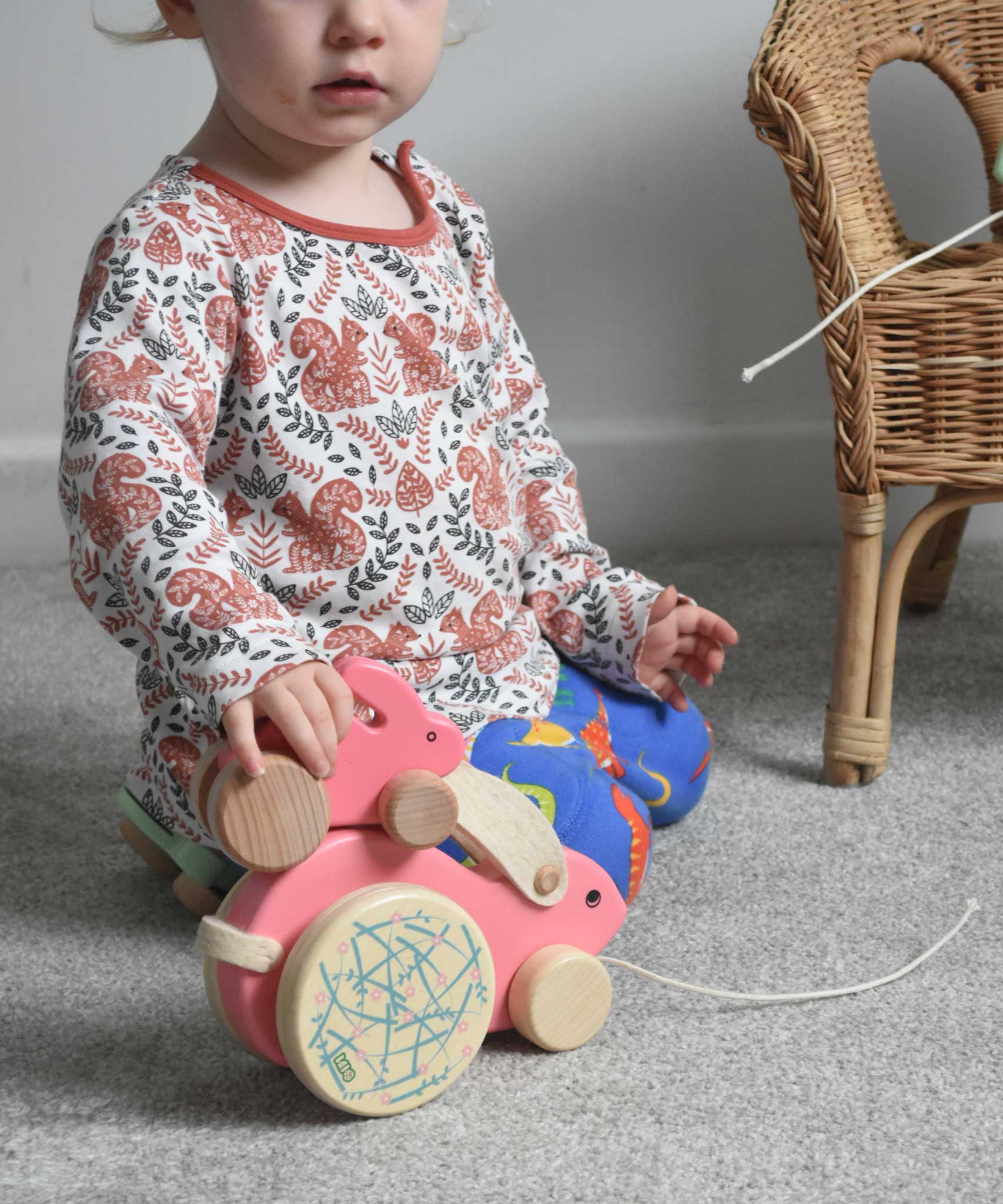 A child placing a small pink Bajo rabbit on top of a big pink Bajo rabbit.  These heirloom quality toys by Bajo are part of a wide range of wooden toys available here at Babipur.