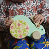 A close up of a child holding the mint coloured big Bajo rabbit toy on their lap. These heirloom quality toys by Bajo are part of a wide range of wooden toys available here at Babipur.