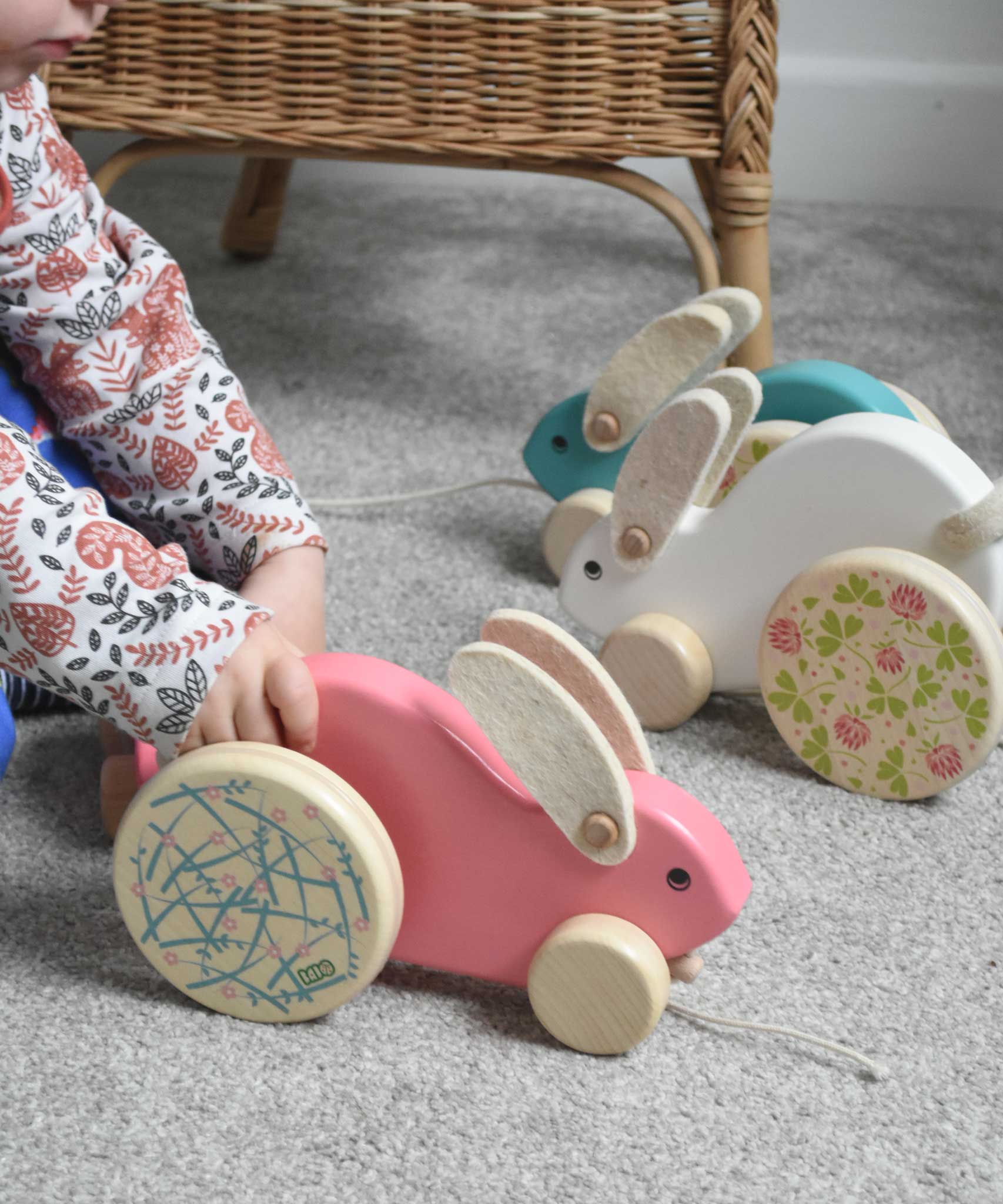 A child pushing the pink coloured Bajo big rabbit. The blue and white rabbits can be seen in teh background. These heirloom quality toys by Bajo are part of a wide range of wooden toys available here at Babipur.