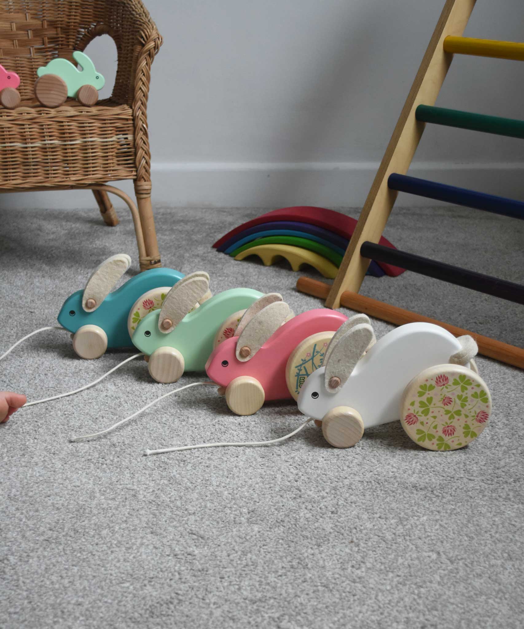 Four Bajo wooden big pull along rabbit toys lined up and placed on the floor in front of a Triclimb. These heirloom quality toys by Bajo are part of a wide range of wooden toys available here at Babipur.
