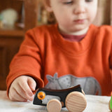 A child playing with the Bajo Pull-Back Caterpillar Toy.  These heirloom quality toys by Bajo are part of a wide range of wooden toys available here at Babipur.