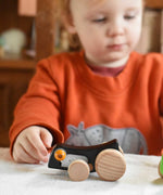 A child playing with the Bajo Pull-Back Caterpillar Toy.  These heirloom quality toys by Bajo are part of a wide range of wooden toys available here at Babipur.