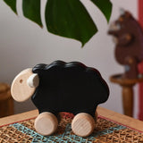 Bajo black sheep push along wooden toy on wheels placed a rattan stool in the Babipur playroom.