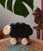 Bajo black sheep push along wooden toy on wheels placed a rattan stool in the Babipur playroom.