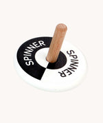 Bajo black and white Spinning Top. A black and white monochrome wooden spinning top with a natural wooden stick with the word spinner written on each half of the circle top.