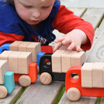 A child playing with a collection of Bajo trucks