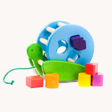 Bajo Blue Snail Sort Roller. A circular shaped wooden shape sorter toy that sits on a pull along snail base. 