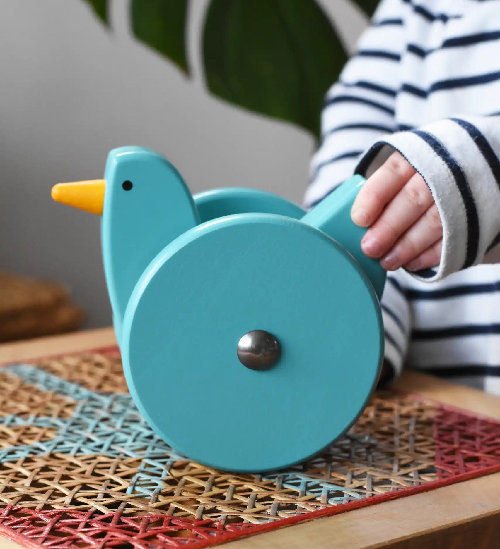 Child playing with the Bajo blue wobbling chicken push along toy.
