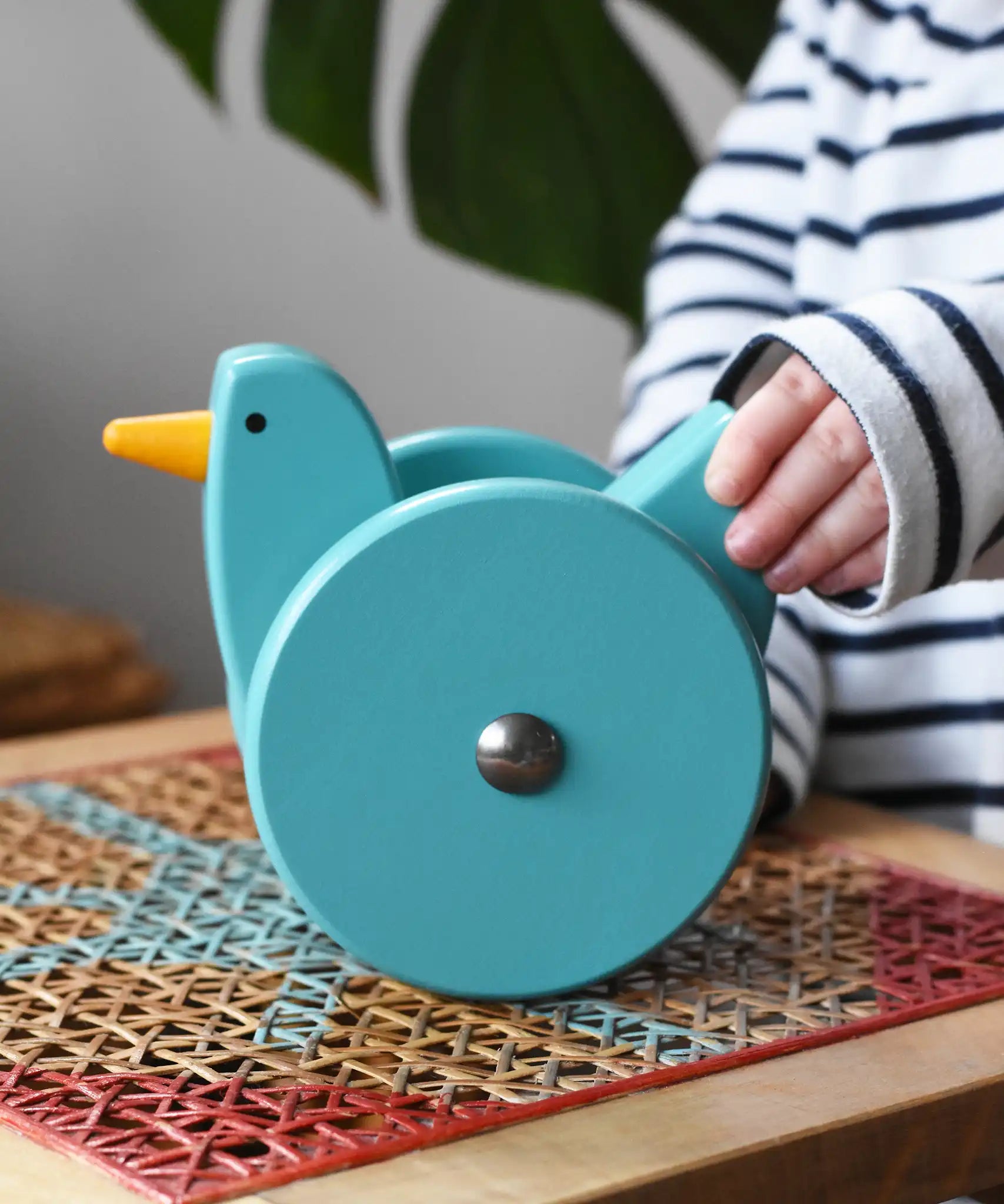 Child playing with the Bajo blue wobbling chicken push along toy.