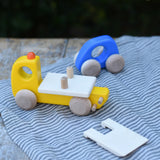 Bajo yellow breakdown lorry wooden toy with a blue coloured car. The ramp is shown taken off the trailer. 