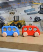 A blue and red wooden Bajo bus placed on a Triclimb Miri slide. These heirloom quality toys by Bajo are part of a wide range of wooden toys available here at Babipur. 