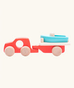 Side of the Bajo toys wooden car with boat and trailer. A coral red vehicle and trailer with a blue boat.