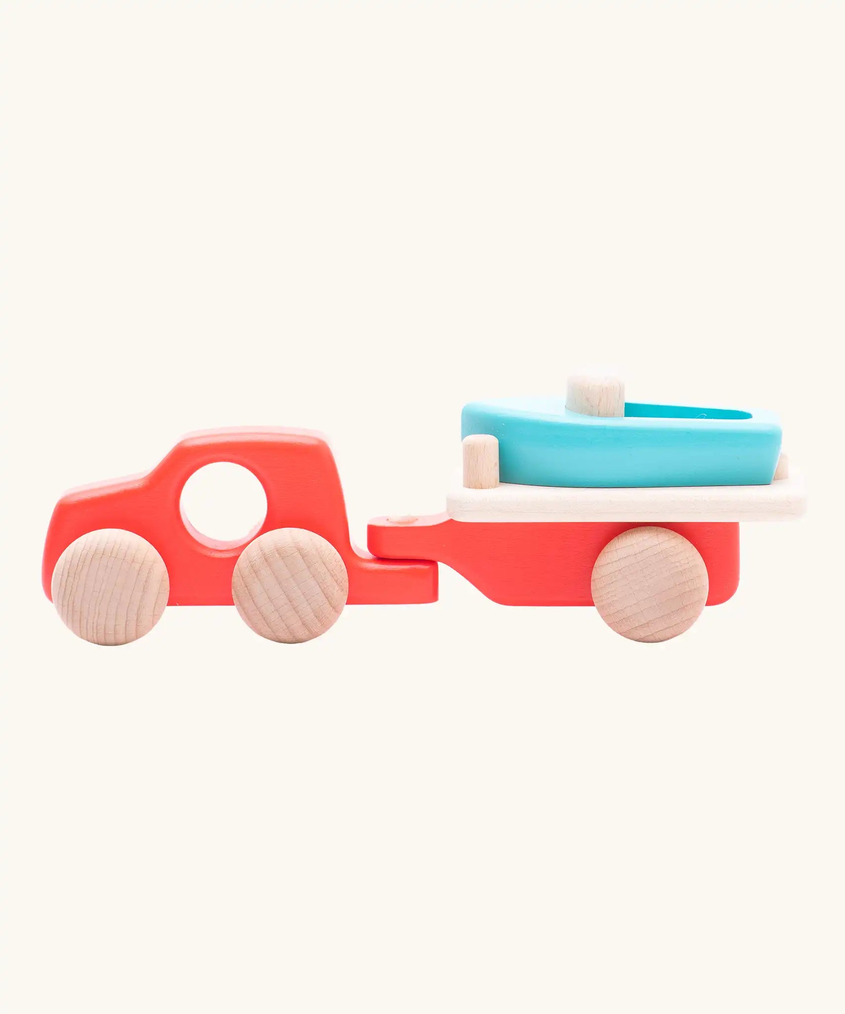 Side of the Bajo toys wooden car with boat and trailer. A coral red vehicle and trailer with a blue boat.