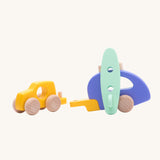 Bajo Car and Camper wooden toy with the pieces detached from each other. There is a yellow car, purple camper trailer and a mint green coloured surf board. These heirloom quality toys are part of a wode range of Bajo wooden toys available here at Babipur.