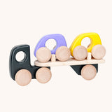 A black coloured Bajo wooden toy car transporter available at Babipur. This black coloured truck has natural wooden wheels and comes with two mini cars, one purple and one yellow.
