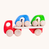 A red coloured Bajo wooden toy car transporter available at Babipur. This red coloured truck has natural wooden wheels and comes with two mini cars, one blue and one green.