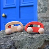 Bajo wooden toy cars with beads push along toys placed on a stone wall outdoors. 