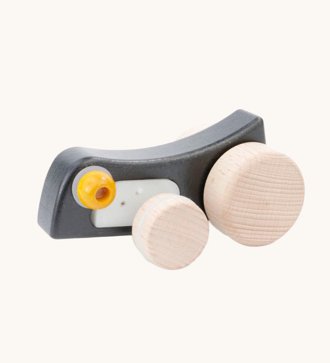 Bajo Pull-Back Caterpillar Toy. A black coloured caterpillar toy that has a yellow eye and natural wooden wheels. 