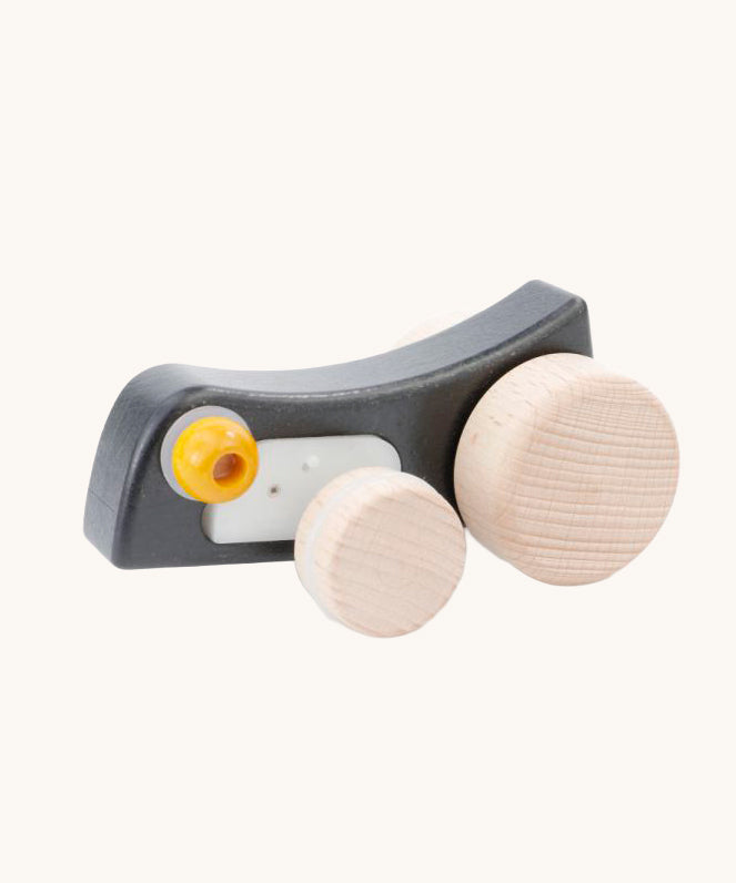 Bajo Pull-Back Caterpillar Toy. A black coloured caterpillar toy that has a yellow eye and natural wooden wheels. 