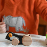 Bajo Pull-Back Caterpillar Toy. A black coloured caterpillar toy that has a yellow eye and natural wooden wheels.  These heirloom quality toys by Bajo are part of a wide range of wooden toys available here at Babipur.