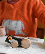 Bajo Pull-Back Caterpillar Toy. A black coloured caterpillar toy that has a yellow eye and natural wooden wheels.  These heirloom quality toys by Bajo are part of a wide range of wooden toys available here at Babipur.