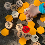 Close up of a hand playing with the Bajo plastic-free hive block toys on a wooden log