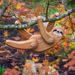 Close up of the Bajo solid wooden sloth toy figure hanging from a tree branch