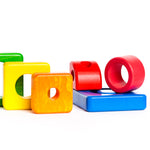 Pieces of the Bajo plastic-free wooden shape stacking toy laid out on a white background
