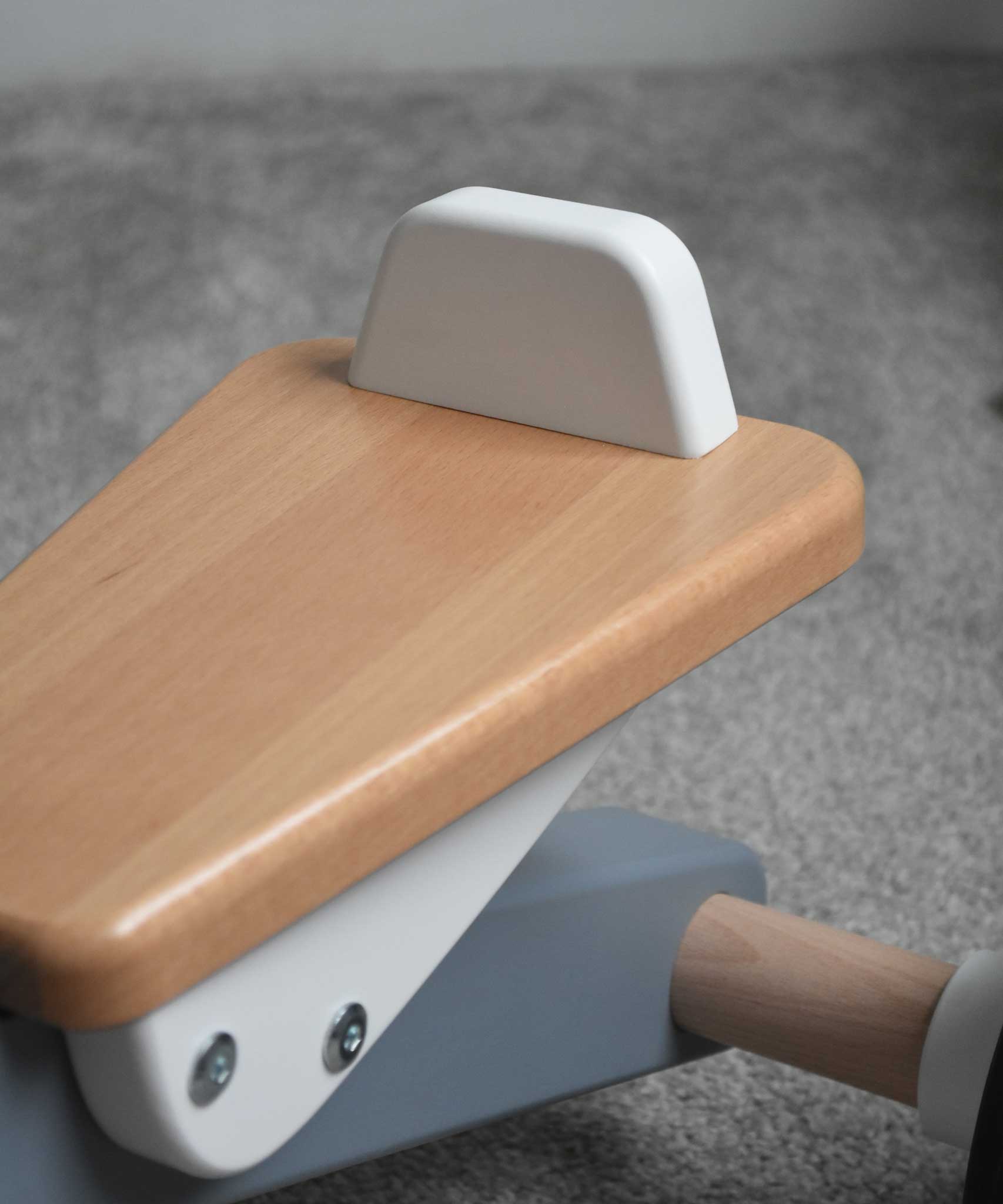 A close up of the white coloured back on the seat of the Bajo Toys wooden Cycle toddler Ride-On in the monochrome, white and grey colourway. The wooden ride on cycle is part of a wode range of wooden toys available here at Babipur. 