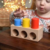 A child playing with the Bajo Deep And Shallow Sorter wooden toy placed on a small wooden table. These heirloom quality toys by Bajo are part of a wide range of wooden toys available here at Babipur. 