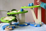 Child playing with the Bajo Dewdrop, Coloured wooden ball run.
