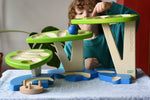 Child playing with the Bajo Dewdrop, Coloured wooden ball run.