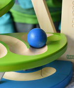 Close up of a blue wooden ball rolling down the track on the Bajo Dewdrop, Coloured wooden ball run.