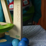 Three blue wooden balls paced besides the Bajo Dewdrop, Coloured wooden ball run.