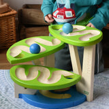 Child playing with the Bajo Dewdrop, Coloured wooden ball run.
