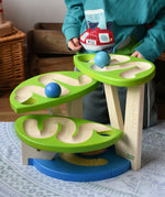 Child playing with the Bajo Dewdrop, Coloured wooden ball run.