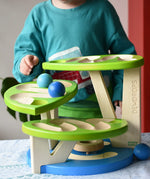 Child playing with the Bajo Dewdrop, Coloured wooden ball run.