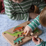 Bajo Wooden Dinosaur Puzzle with 6 colourful figures. Children placing the figures into the shaped slots on the base.