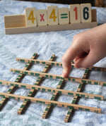 Bajo toys wooden easy maths learning set. Child placing their finger on the pieces that cross.