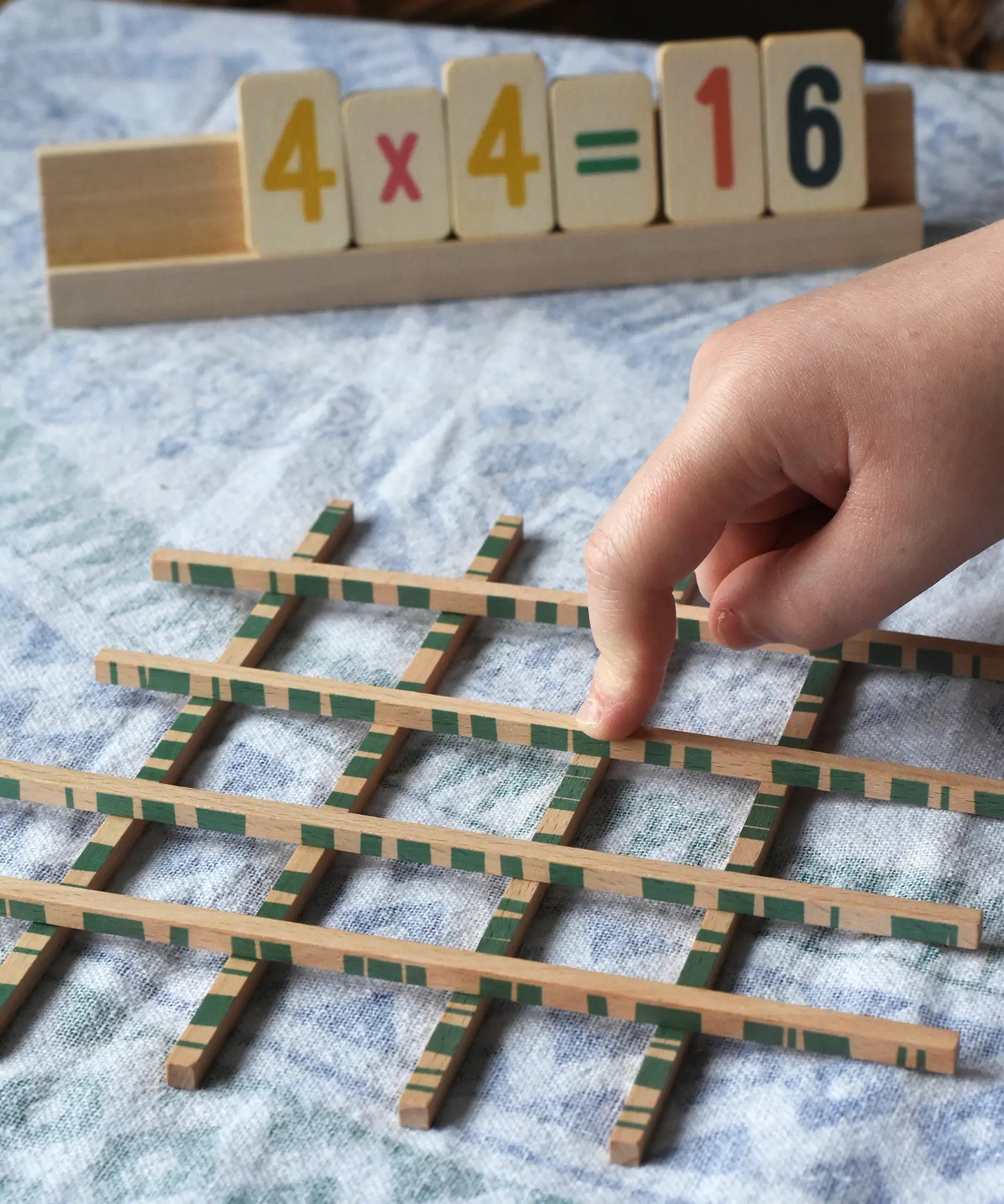 Bajo toys wooden easy maths learning set. Child placing their finger on the pieces that cross.