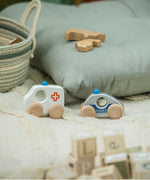 The Bajo ambulance and police car from the emergency vehicle set placed on a rug. These heirloom quality toys by Bajo are part of a wide range of wooden toys available here at Babipur. 