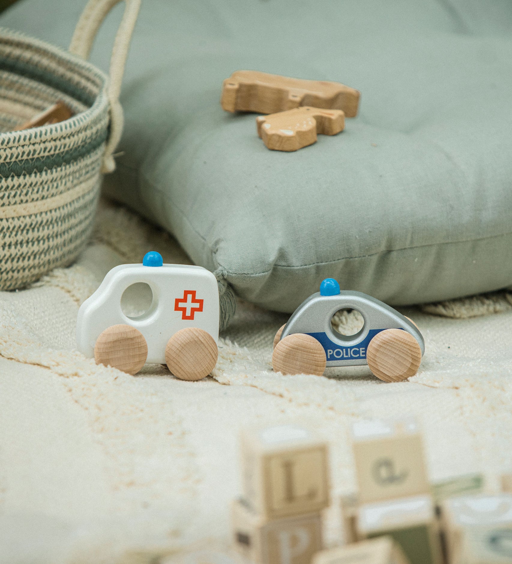 The Bajo ambulance and police car from the emergency vehicle set placed on a rug. These heirloom quality toys by Bajo are part of a wide range of wooden toys available here at Babipur. 