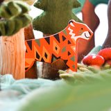 A Bajo tiger endangered wooden toy animal figure placed in a small world play scene with trees and green coloured cloths. These heirloom quality toys by Bajo are part of a wide range of wooden toys available here at Babipur. 