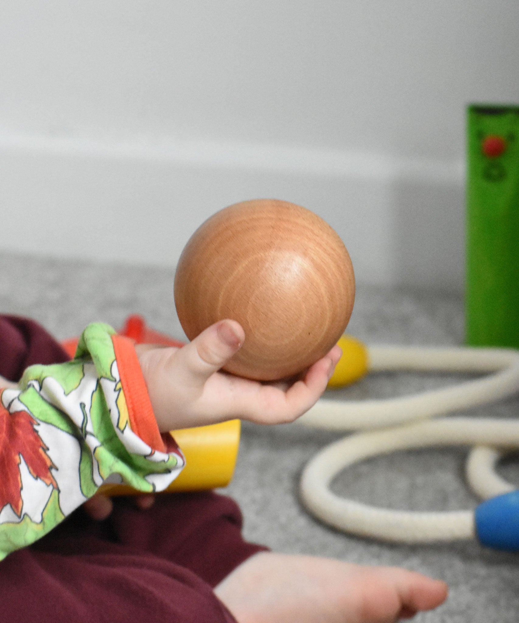 A large wooden ball in a child's hand. This ball is included in the Bajo fellow skittles set. These heirloom quality toys by Bajo are part of a wide range of wooden toys available here at Babipur.