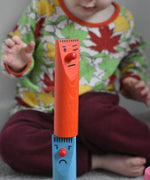 A child stacking pieces from the Bajo Fellow Skittles wooden toy game on top of each other.  These heirloom quality toys by Bajo are part of a wide range of wooden toys available here at Babipur.