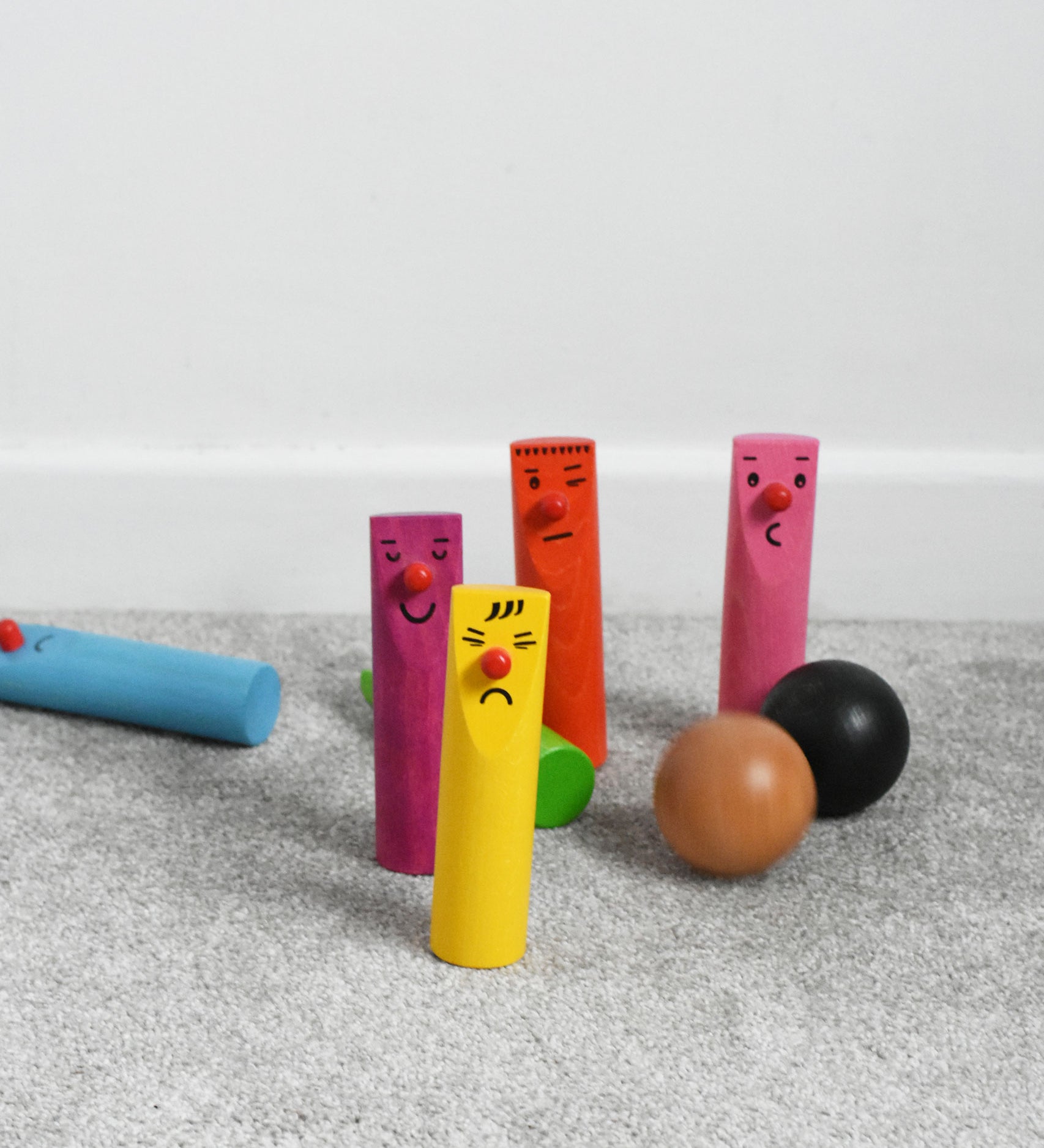 Bajo Fellow Skittles wooden toy game. Six coloured wooden skittles decorated with faces with red noses. The set comes with two wooden balls.  These heirloom quality toys by Bajo are part of a wide range of wooden toys available here at Babipur.