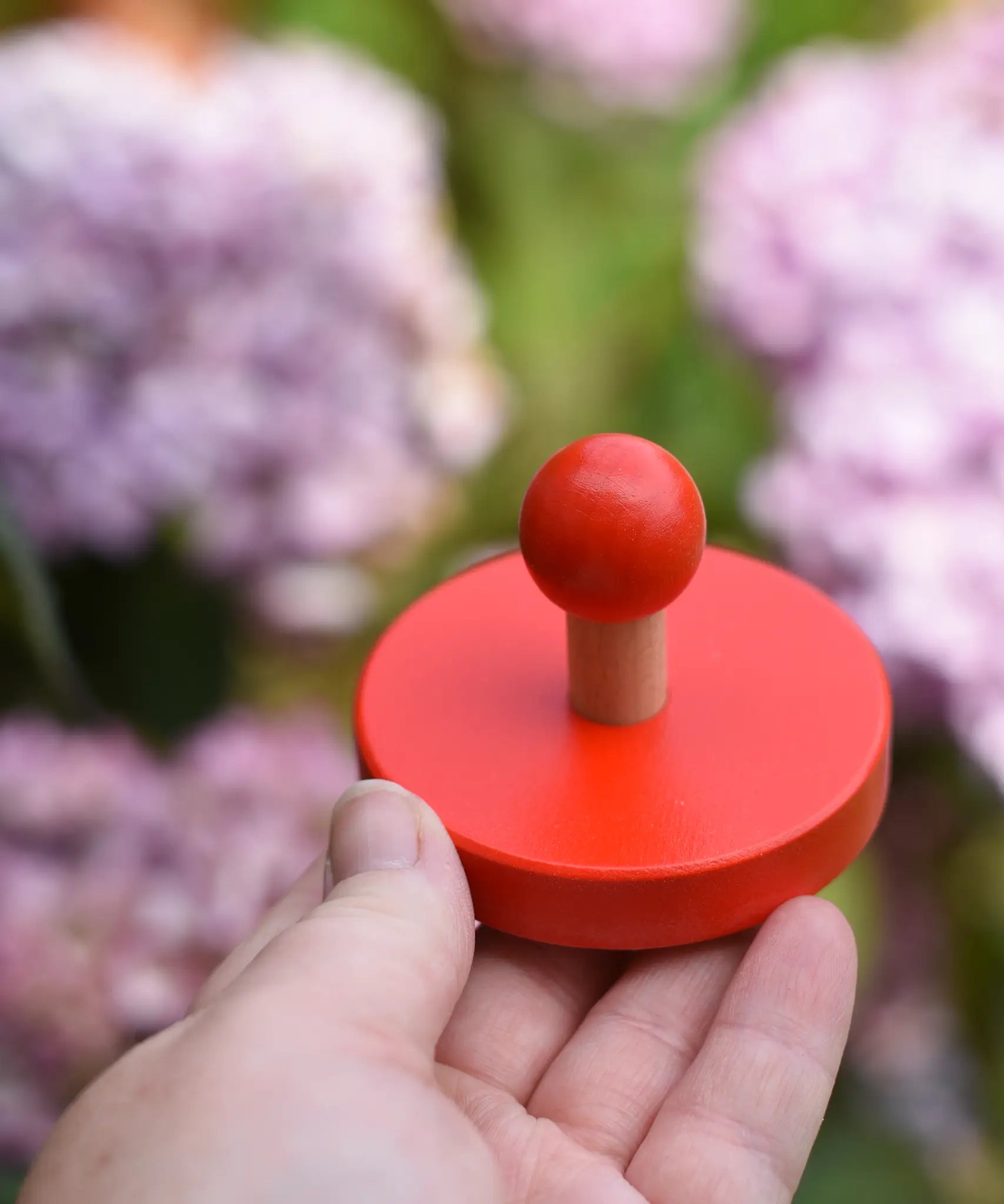Red circles pieces from the Bajo figures shapes sorting board in an adult's hand