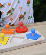 Bajo figures shapes sorting board placed on a Miri with some pieces taken out and placed besides the base frame.